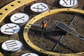 A municipal service worker mows the grass on the face of a flower clock in Kyiv