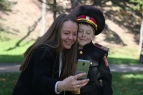 A woman takes a picture with a cadet of Lyceum 23 "Cadet Corps"