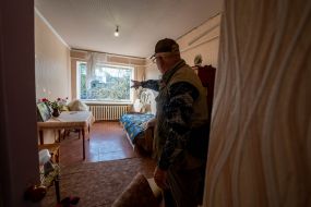 A man in his apartment in a building damaged by an aerial bomb explosion