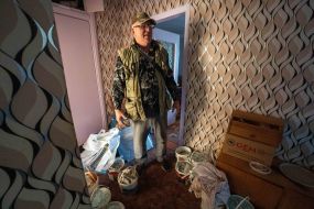 A man in his apartment in a building damaged by an aerial bomb explosion