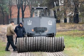 A specialist from the engineering development team talks with a sapper from the State Emergency Service near the MP3101 demining machine