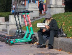 An elderly man reads a newspaper in the center of Kyiv