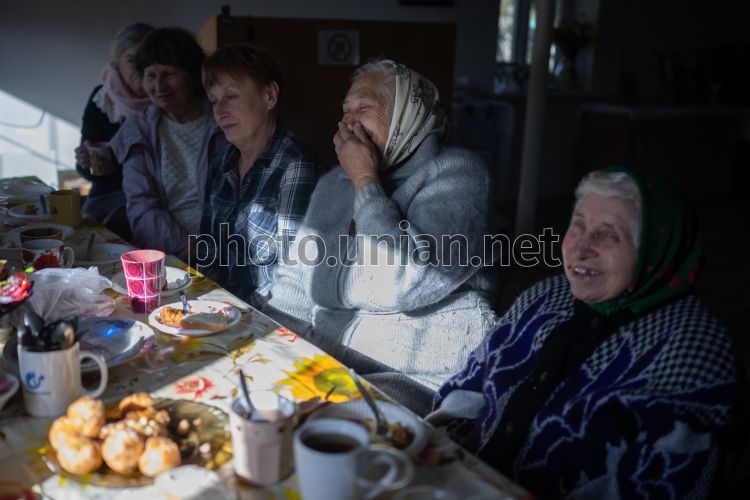 Женщина сидит за столом с ноутбуком и фотографией женщины, работающей над ним