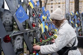 On the Day of Dignity and Freedom, a woman with flowers near the Memorial of the Heroes of the Heavenly Hundred