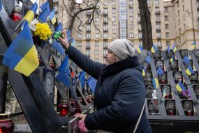 On the Day of Dignity and Freedom, a woman with flowers near the Memorial of the Heroes of the Heavenly Hundred