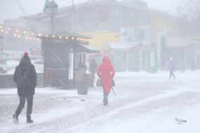 Перехожі на засніженій вулиці в Києві