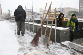 Мітла та лопати стоять біля входу в підземний перехід на вулиці в Києві