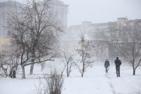 Перехожі на засніженій вулиці в Києві