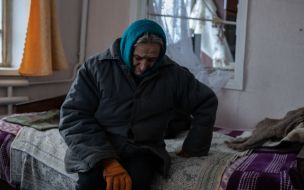 Жінка в пошкодженому внаслідок ракетного обстрілу  будинку