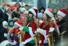 Children in elf costumes play saxophones