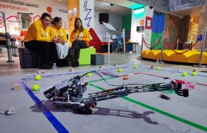 Волонтеры наблюдают за одним из авторских проектов на финальных соревнованиях среди учащейся молодежи в категории "Робототехника"