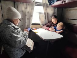 Пожилая женщина и женщина с ребенком на руках в вагоне эвакуационного поезда в городе Покровск