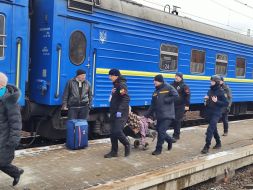 Сотрудники ГСЧС и полиции помогают в эвакуации женщины на инвалидной коляске на вокзале в городе Покровск