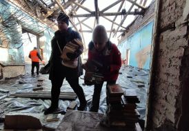 The workers of the destroyed school take away the books that remained after the shelling