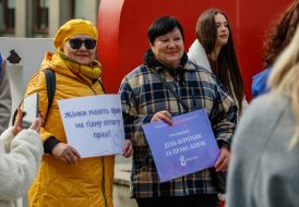 Participants of "Walk in Different Shoes for Gender Equality" hold banners