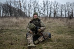 A military recruit rests during military exercises