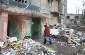 A woman near one of the entrances of a 9-story residential building in the city of Myrnograd damaged as a result of Russian rocket fire