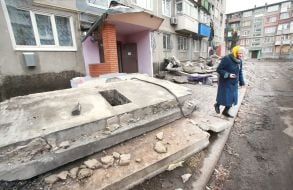 An elderly woman near a 5-story residential building destroyed by Russian rocket fire in the city of Myrnograd