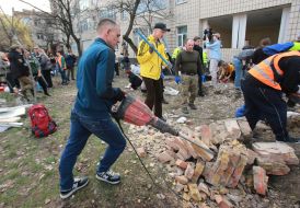 Volunteers clear away the rubble of the Academy of Decorative and Applied Arts building
