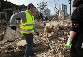 Volunteers clear away the rubble of the Academy of Decorative and Applied Arts building
