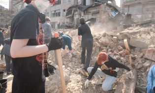 Volunteers clear away the rubble of the Academy of Decorative and Applied Arts building