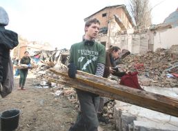 Volunteers clear away the rubble of the Academy of Decorative and Applied Arts building