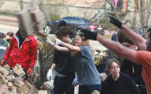 Volunteers clear away the rubble of the Academy of Decorative and Applied Arts building