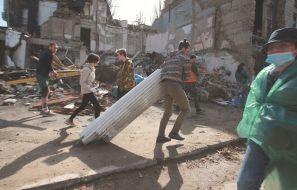 Volunteers clear away the rubble of the Academy of Decorative and Applied Arts building