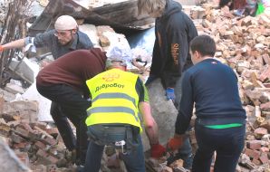 Volunteers clear away the rubble of the Academy of Decorative and Applied Arts building