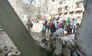 Volunteers clear away the rubble of the Academy of Decorative and Applied Arts building