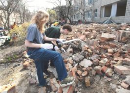Volunteers clear away the rubble of the Academy of Decorative and Applied Arts building