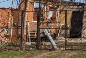 Engine from a Smerch MLRS shell near a destroyed house