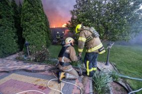 Rescuers extinguish a fire in a private house caused by a rocket attack in Kharkov