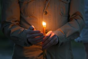A believer holds a candle in his hands