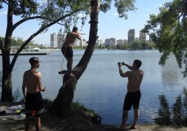 Men jump from a bungee cord into the water at Lake Sonyachne in Kyiv