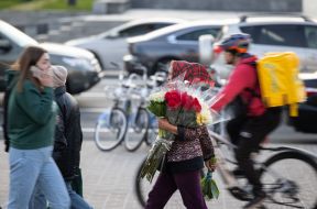 Woman with flowers near delivery courier