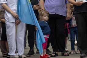 A girl holds the Crimean Tatar flag at the railway station in Odessa