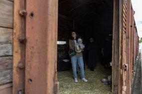 A woman with a child in a freight car, similar to the one that transported Crimean Tatars from Crimea to Uzbekistan, at the railway station in Odesa
