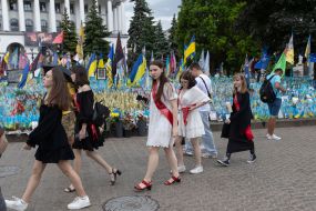 A graduate near the flags in memory of the fallen defenders of Ukraine