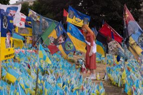 A graduate near the flags in memory of the fallen defenders of Ukraine