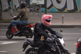 Мужчина за рулем мотоцикла в шлеме, декорированном маской свиньи