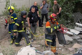 Rescue workers are sorting through the rubble of a house in Kharkiv destroyed by an explosion of Russian ammunition