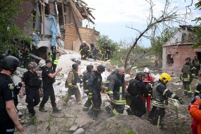 Спасатели вывозят на медицинских носилках 75-летнего мужчину из-под завалов дома в Харькове
