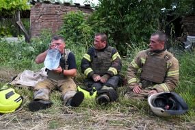 Спасатели отдыхают после разбора завалов разрушенного взрывом российского боеприпаса дома в Харькове
