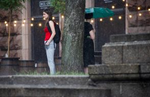 A girl stands in the rain in the center of Kyiv