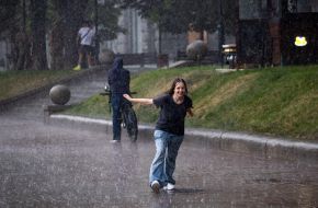 A girl stands in the rain in the center of Kyiv