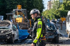 A rescuer works near a destroyed residential building in Kharkiv