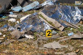 Rescuers carry the body of a deceased person in a bag near an apartment building that was destroyed by shelling in Kharkiv