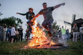 Участники празднования Ивана Купала прыгают через костер в селе Витачев под Киевом