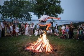 Участник празднования Ивана Купала прыгает через костер в селе Витачев под Киевом
